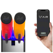 Load image into Gallery viewer, A dual Slush machine with two dispensers filled with orange and red slush, glowing with blue LED light, shown next to a hand holding a smartphone displaying the V-AIR app.